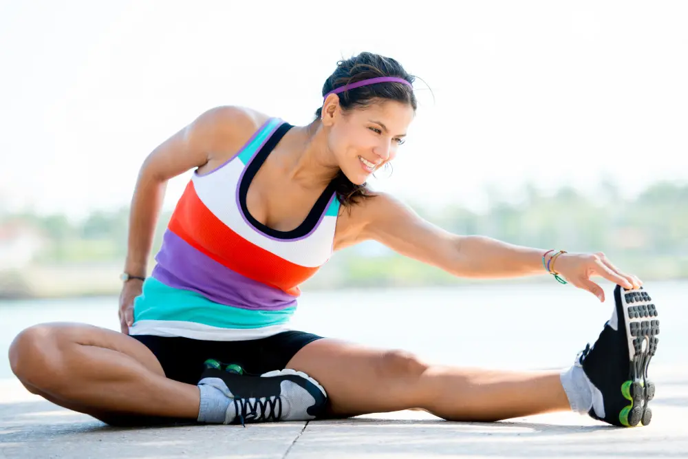 Castellano-Blog-Apr20 Fit woman doing stretching exercises outdoors and smiling.