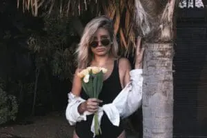 woman standing by a palm tree