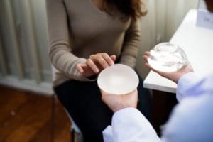 Woman looking at her breast implant options with her surgeon.