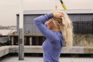 Woman holding her long hair up before she works out.