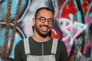 man in front of grafitti wall